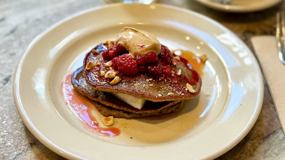 Banana pancakes with raspberry, hazelnut and maple syrup.