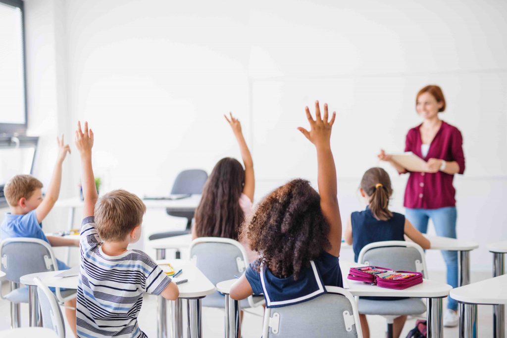 children raising hands in class