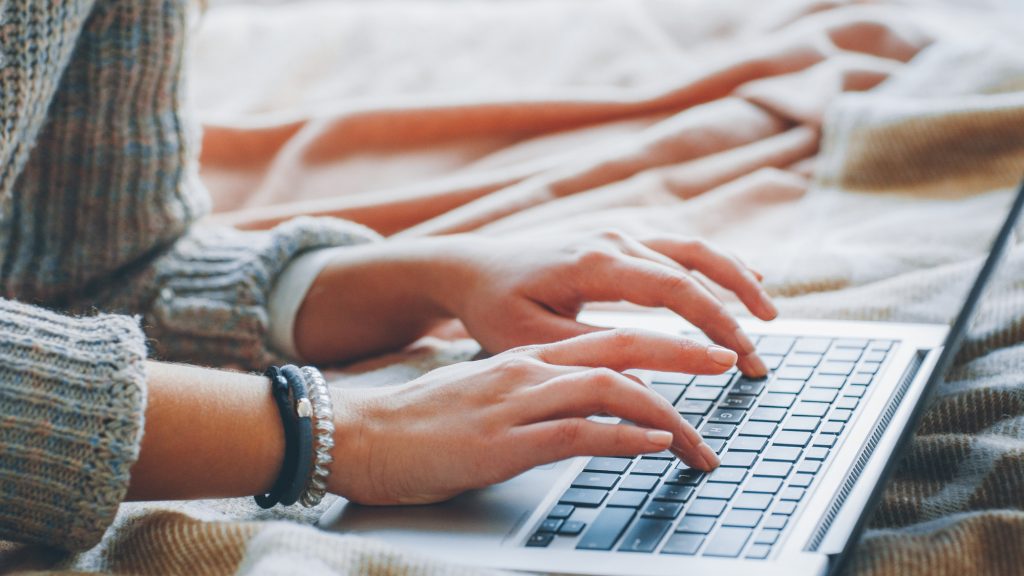 Closeup of female hands typing on laptop